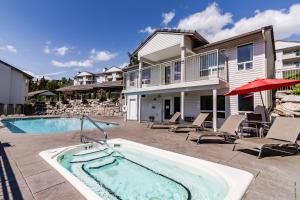 einen Pool mit Stühlen und ein Haus in der Unterkunft Park Pointe Condominiums in Chelan