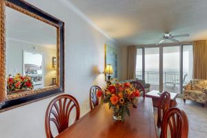 a dining room with a table and a mirror at Emerald Beach Resort in Panama City Beach