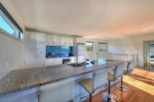 a kitchen with a counter with chairs and a counter top at Deja Blu 2 in Coles Bay