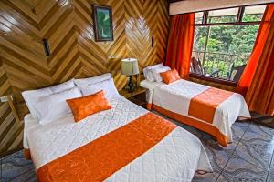 a bedroom with two beds and a window and a room at Mar Inn Costa Rica in Monteverde Costa Rica