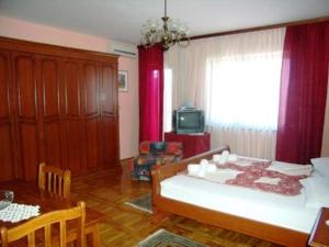 a living room with a bed and a dining table at Guest House Sunce in Novi Vinodolski