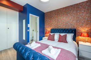 - une chambre avec un grand lit et un mur en briques dans l'établissement Cozy and Charming Flat: Minutes from Everything!, à Londres