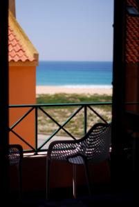 uma varanda com 2 cadeiras e vista para o oceano em Casas da praia Supertubos em Peniche