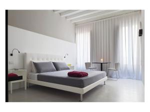 ローマにあるカーサ デ コロナーリの白いベッドルーム(ベッド1台、テーブル付)