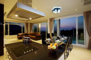 a kitchen and living room with a table and chairs at Kata Sea View Villas in Kata Beach