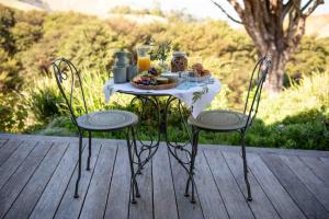 a table with a plate of food and drinks on it at Waiheke Luxury Blue and Green Rooms in Ostend