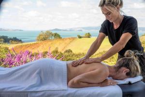 una mujer dándole a un hombre un masaje de espalda en Waiheke Luxury Blue and Green Rooms, en Ostend