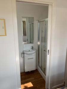 a white bathroom with a sink and a shower at Horsham Riverside Caravan Park in Horsham