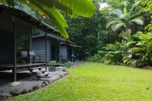 a small house with a grassy yard in front of it at Safari Lodge in Cape Tribulation