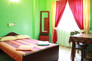 a bedroom with a bed with a mirror and a desk at Wijaya Tourist INN in Warakapola
