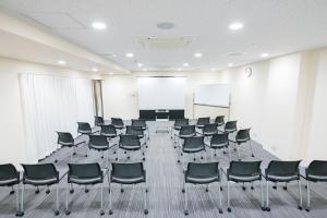 a conference room with chairs and a projection screen at Matsuyama Tokyu REI Hotel in Matsuyama