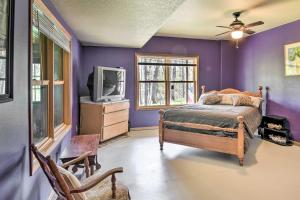 - une chambre avec des murs violets, un lit et une télévision dans l'établissement Raccoon River Retreat Indoor Pool and Outdoor Fun!, à Adel