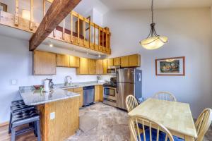 a kitchen with wooden cabinets and a table with chairs at Buffalo Ridge Condos in Silverthorne