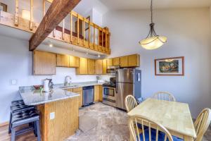 eine Küche mit Holzschränken und einem Tisch mit Stühlen in der Unterkunft Buffalo Ridge Condos in Silverthorne