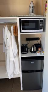 a kitchen with a microwave and towels on a shelf at Short Stays Gippsland (Newborough) in Moe