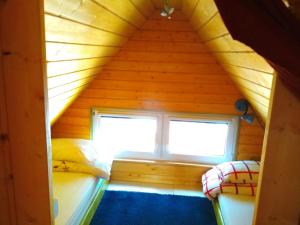 Habitación con 2 camas y ventana en una cabaña de madera. en PEPASÓWKA Chatka Puchatka, en Łukęcin