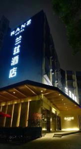 un edificio con una señal azul en el costado. en Shenzhen Yanan Hotel, en Shenzhen