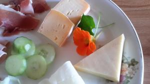 a plate of cheese and vegetables on a table at Pension Staldacher in Hasliberg