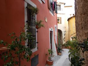 een steegje met potplanten aan de zijkant van een gebouw bij Le Campanin in Menton