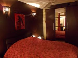 1 dormitorio con cama roja y espejo en Le Campanin, en Menton
