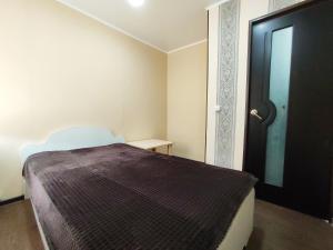 a bedroom with a bed and a black door at Апартаменты на Сайдашева 3 in Bugul'ma