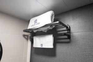 un portasciugamani con asciugamani appesi a una parete in bagno di Studio Stay a Hong Kong