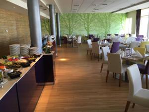 Aqua Apartman Superior في فيلينس: غرفة طعام مع طاولات وكراسي بيضاء