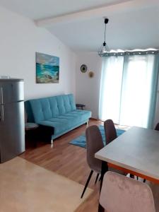 - un salon avec un canapé bleu et une table dans l'établissement Apartman Šime, à Tribunj