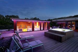 a house with a hot tub and chairs on a deck at FAVORITE Parkhotel in Mainz
