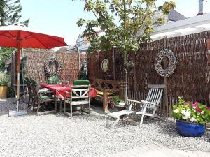 Un patio con una mesa y sillas y una sombrilla. en Altes Strandhus Casa Seestern, en Scharbeutz