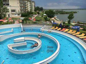a large swimming pool with people in the water at Aqua Apartman Superior in Velence