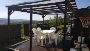 un patio con mesa y sillas bajo una pérgola en Ferienwohnung S. Armbruster, en Bernsbach