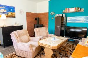 un soggiorno con 2 sedie, un tavolo e una TV di Ferienbungalow Kroeslin a Kröslin