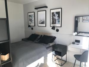 a bedroom with a bed and a desk and pictures on the wall at Apartamenty Świnoujście - Wyspiańskiego 34e in Świnoujście
