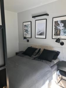 a bedroom with a bed and three pictures on the wall at Apartamenty Świnoujście - Wyspiańskiego 34e in Świnoujście
