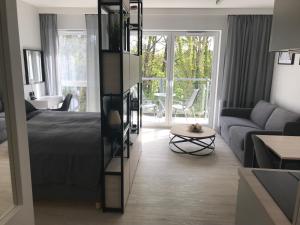 a bedroom with a bed and a living room with a couch at Apartamenty Świnoujście - Wyspiańskiego 34e in Świnoujście
