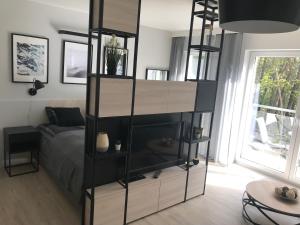 a bedroom with a bed and a black book shelf at Apartamenty Świnoujście - Wyspiańskiego 34e in Świnoujście