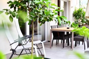 un tavolo e sedie su un balcone con piante di Apparthotel Gartenresidence Nalserhof a Nalles
