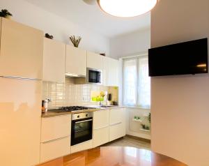 a kitchen with white cabinets and a stove top oven at Butterfly Suite Rome in Rome