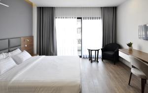 una camera d'albergo con un grande letto e una scrivania di Royal Dragon Boutique Hotel ad Ho Chi Minh