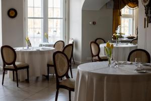 a dining room with two tables and chairs at Malpils Manor in Mālpils