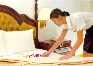 een vrouw legt bloemen op een bed bij Huang Tai Hotel in Jiaoxi