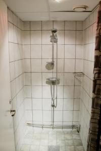 ストックホルムにあるKlara Hostel Stockholmの白いタイル張りのバスルーム(シャワー付)