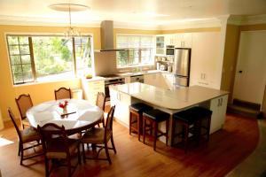 a kitchen with a table and a kitchen with a table and chairs at Somersal Bed & Breakfast in Pirongia