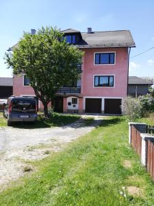 a pink house with a car parked in the driveway at Feriendomizil Wachau in Habruck