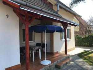 a patio with an umbrella and a table and chairs at Nice House on the Beach in Balatonfenyves