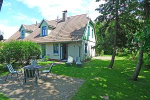 a house with chairs and a table in the yard at Ferienhaussiedlung Strandperlen Küstenhof 3d (Typ IV) in Wustrow