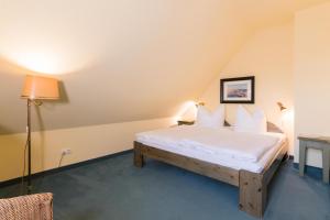a bedroom with a bed with white sheets and pillows at Ferienhaussiedlung Strandperlen Küstenhof 3d (Typ IV) in Wustrow +15 photos