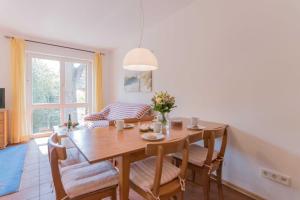 a kitchen and dining room with a wooden table and chairs at Landhaus DADDELDU Whg. V-D2 (hinten) in Ahrenshoop