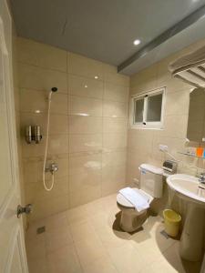 een badkamer met een douche, een toilet en een wastafel bij 雅舍 Arthur Hostel in Jinning